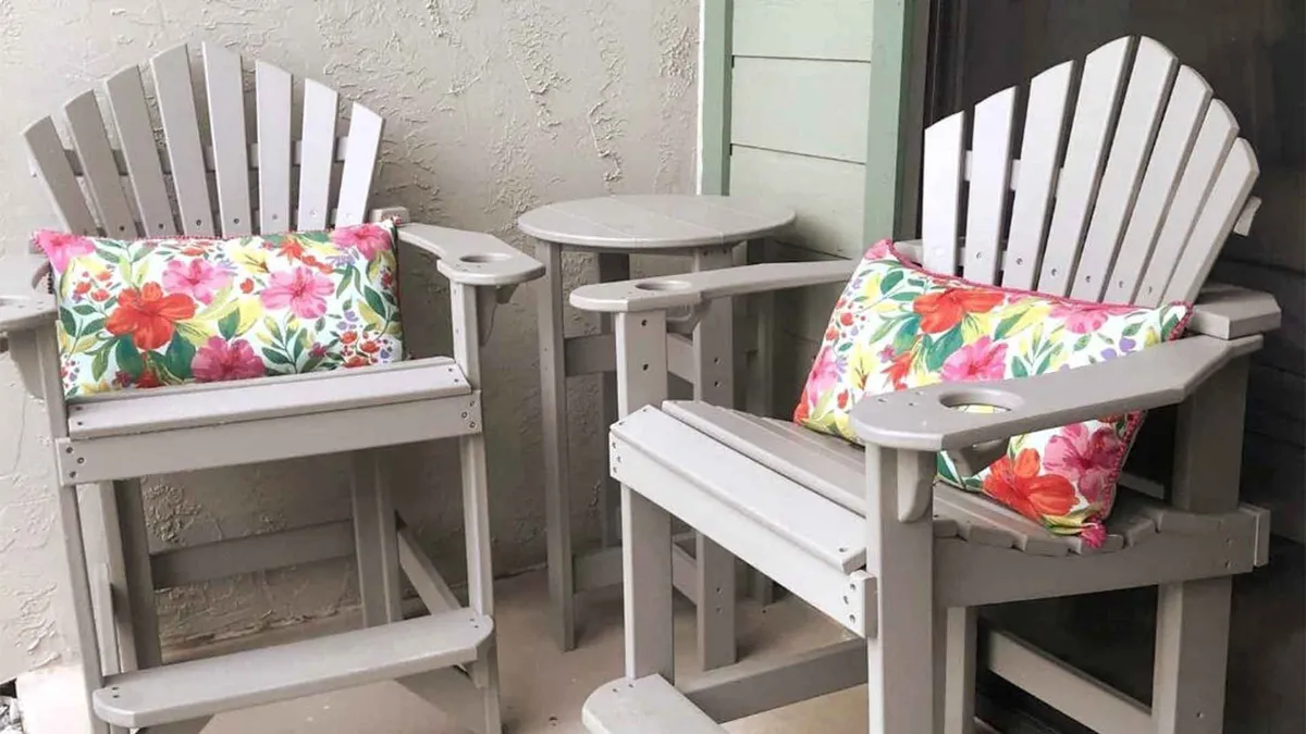 This image captures a cozy patio setting with Adirondack chairs adorned in colorful floral pillows and a small round table, providing a welcoming outdoor nook. The setup suggests a private, tranquil space for enjoying coffee or conversation while soaking in the fresh mountain air.